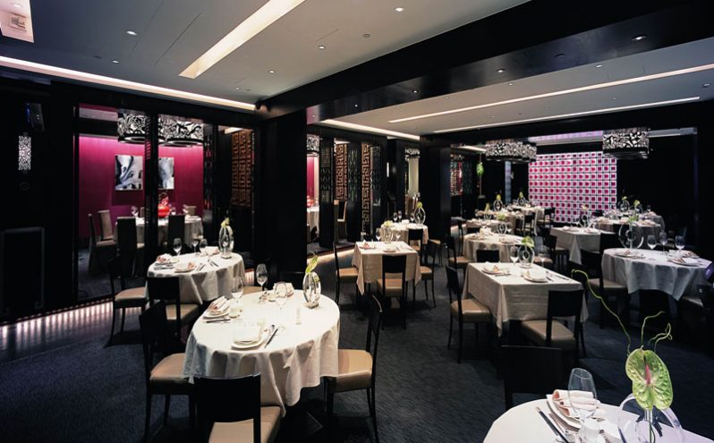 餐厅装修深色调餐区 餐厅装修深色调餐区,暗红色金丝绒装饰墙面。