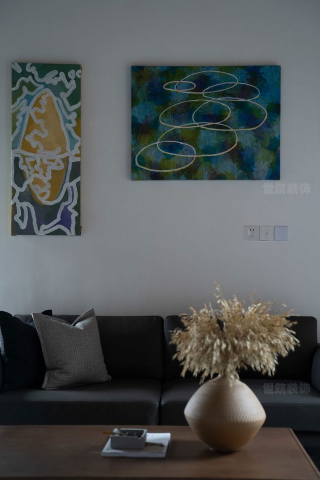 黑色沙发上的艺术挂画